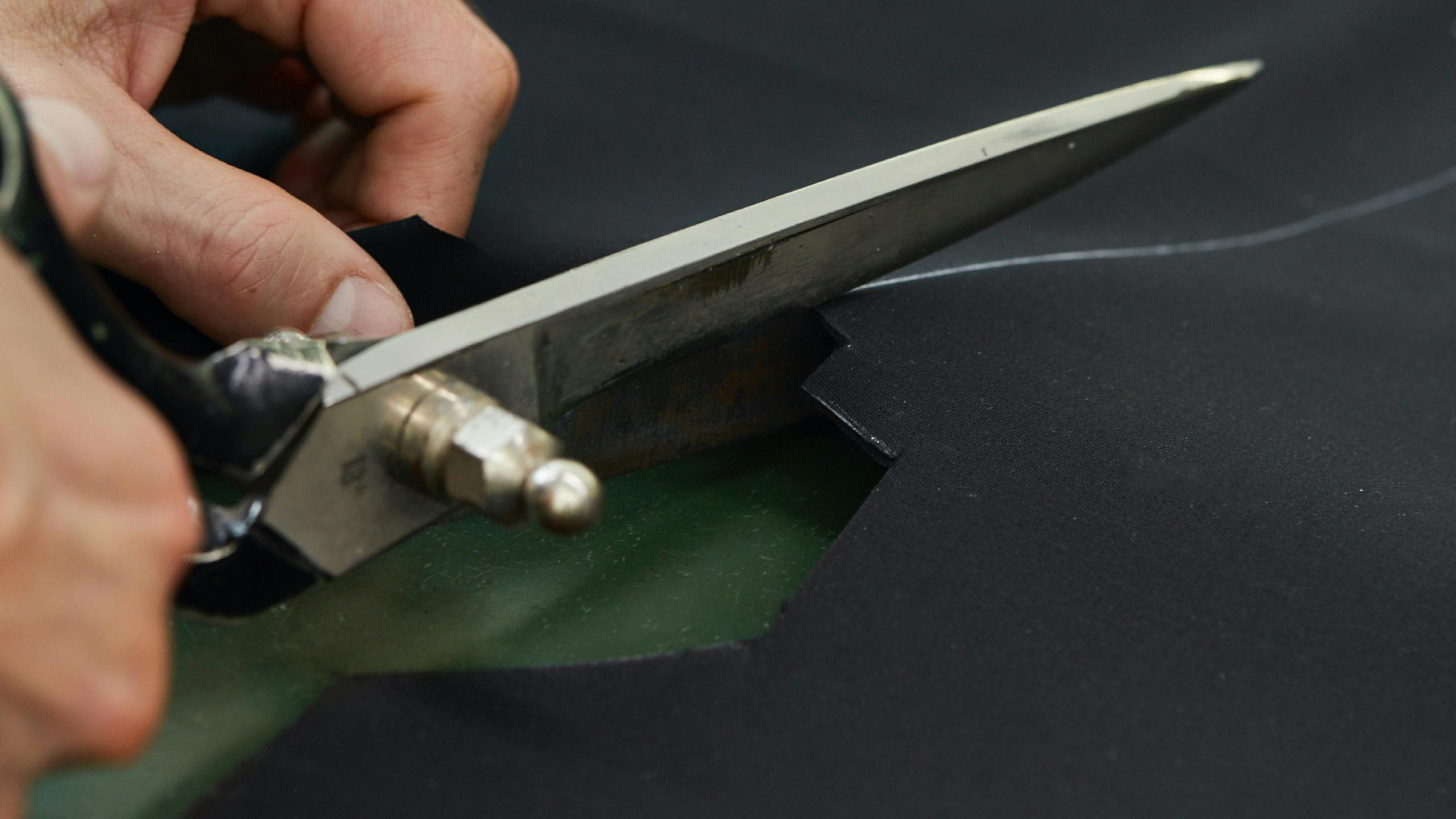 A Brioni artisan cutting a fabric