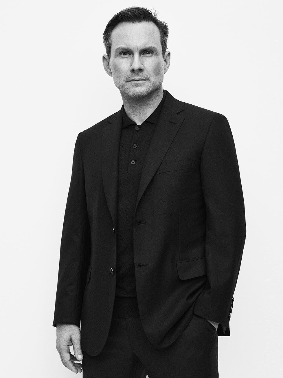 Christian Slater wearing a blazer, polo knit and trousers from the Brioni Essential collection