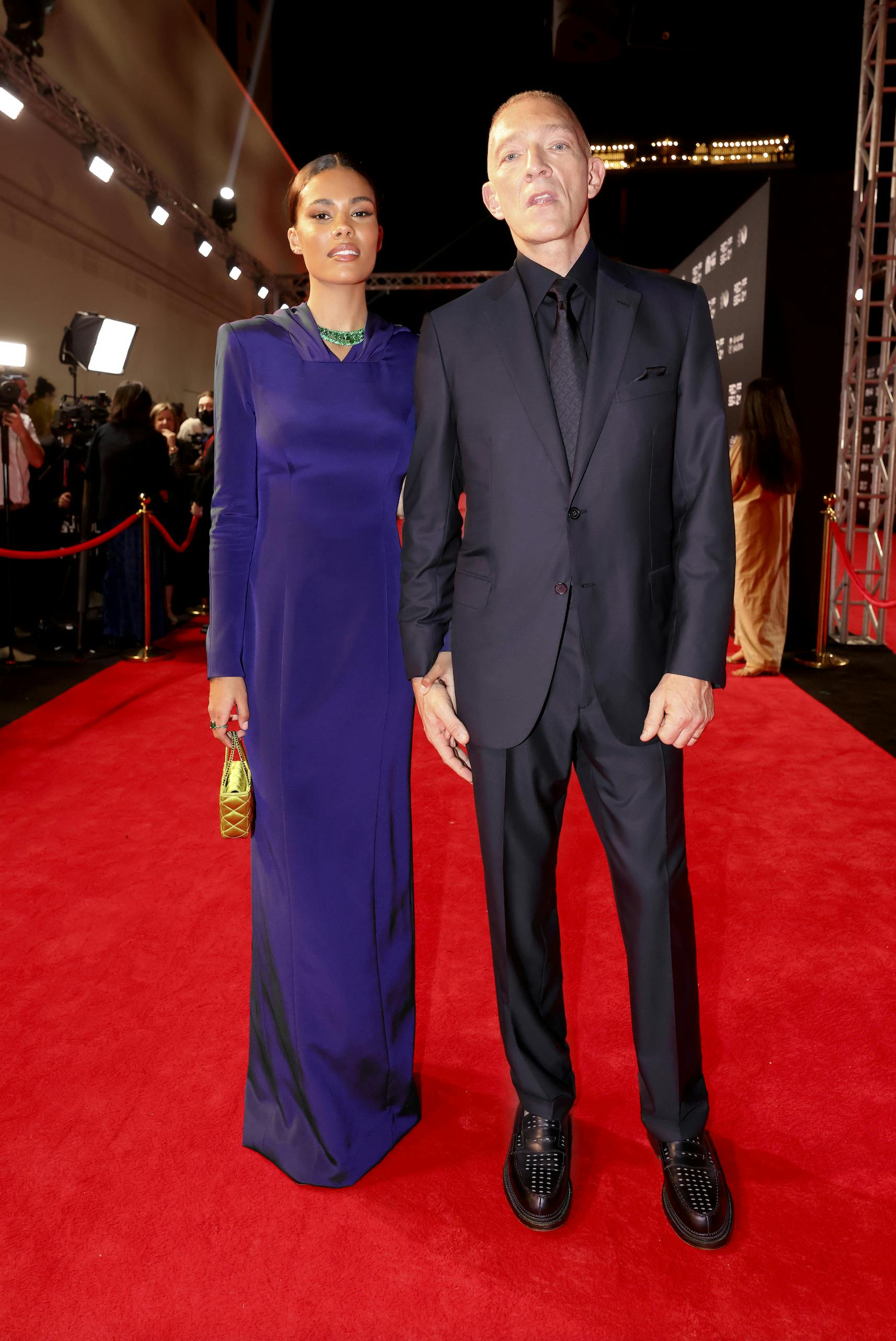 Vincent Cassel, pictured with Tina Kunakey, wearing a Brioni blue suit