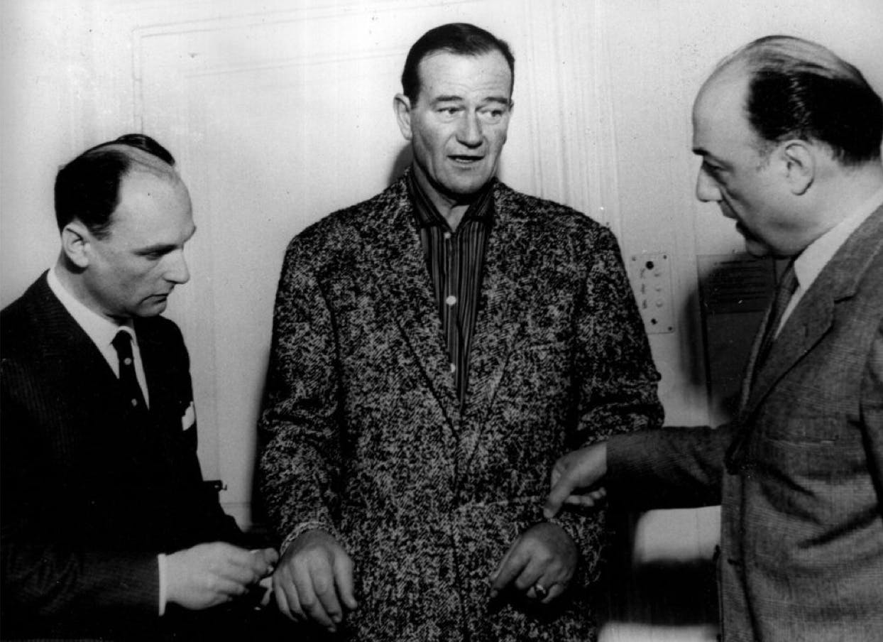 American actor John Wayne is fitted for a Brioni suit in the atelier in Rome, 1950s